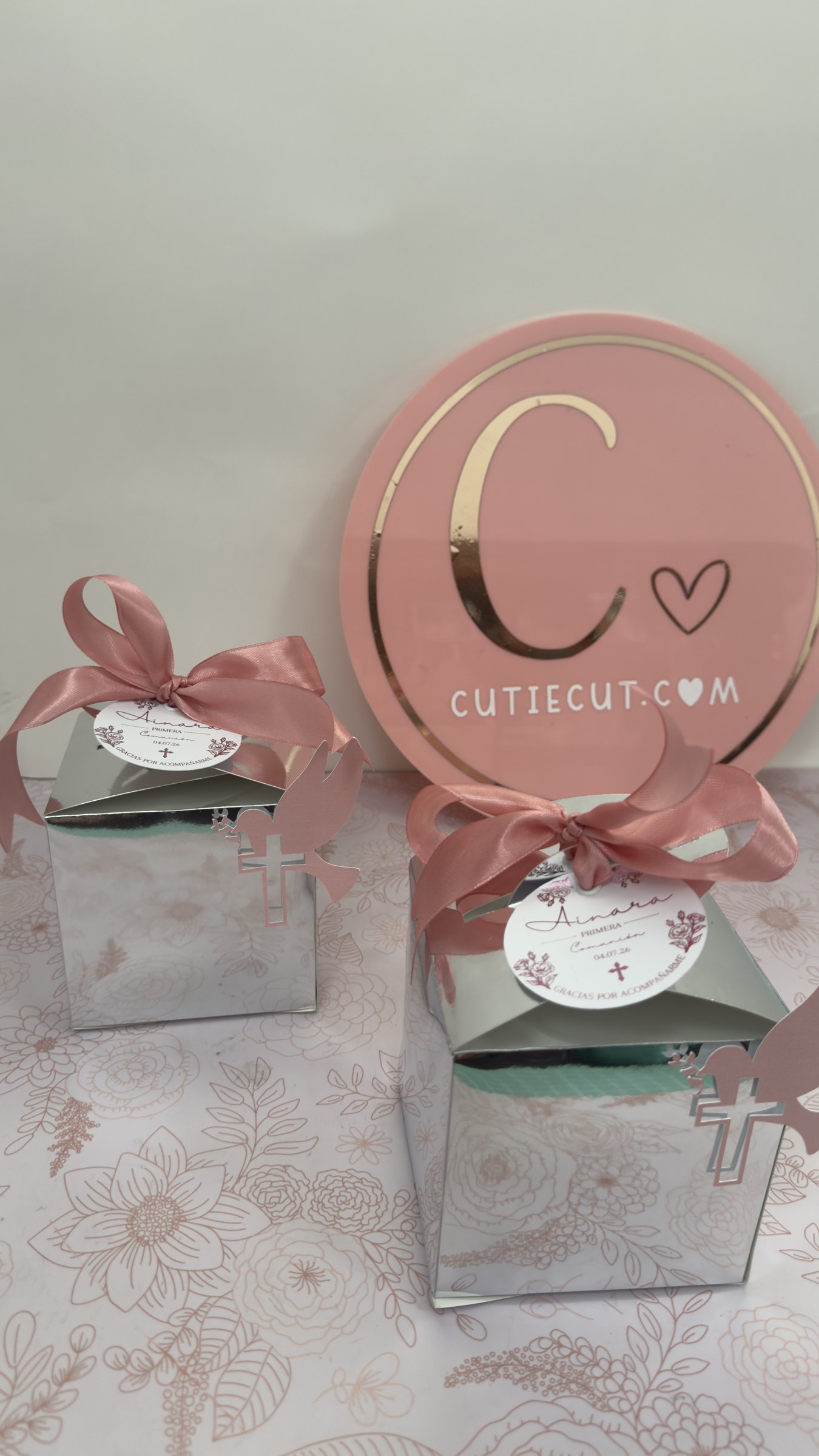 Cajitas de recuerdo con moños rosas y etiquetas personalizadas